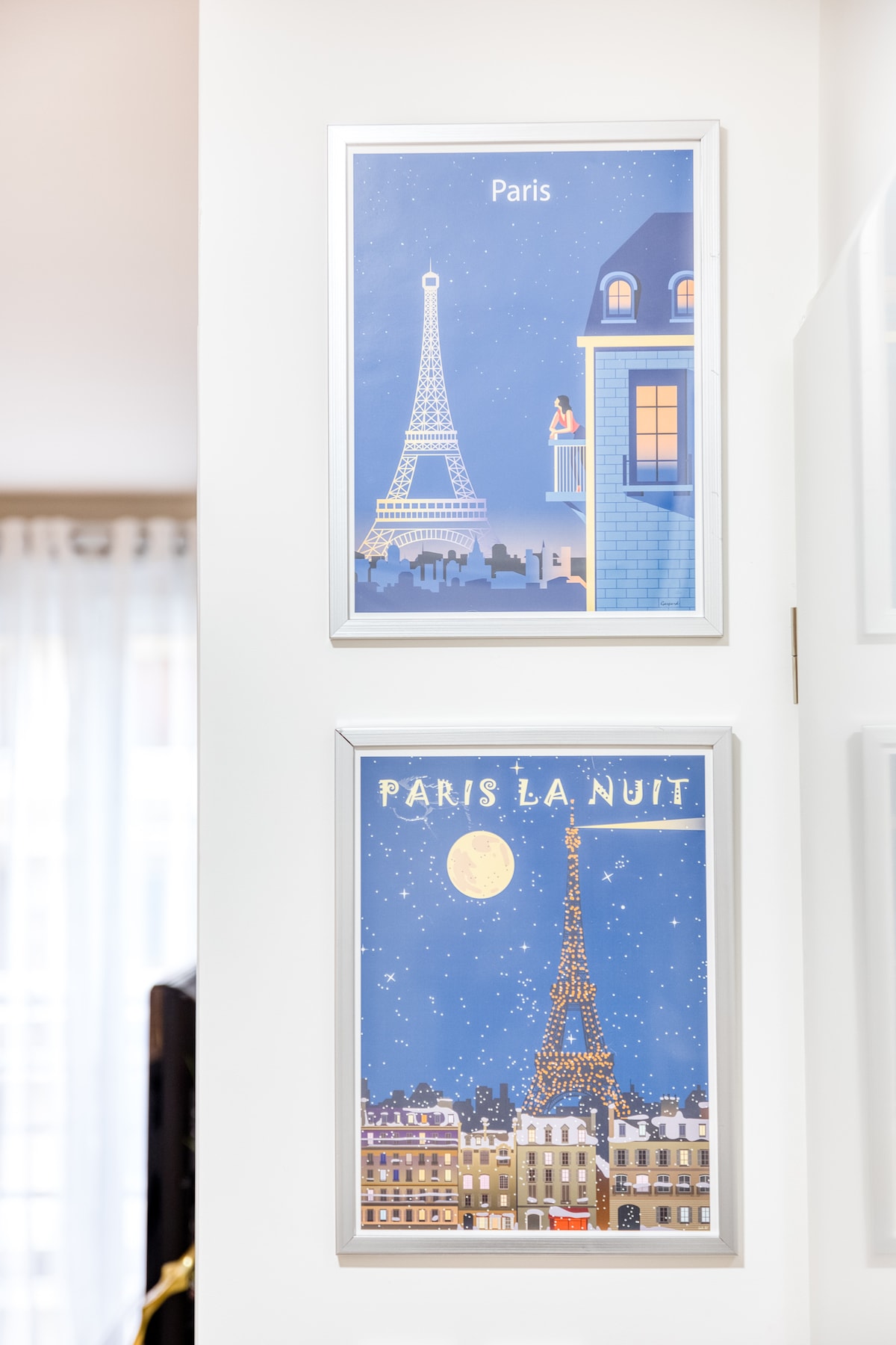 Couloir — Murs blancs épurés, affiches Paris encadrées, lumière naturelle douce