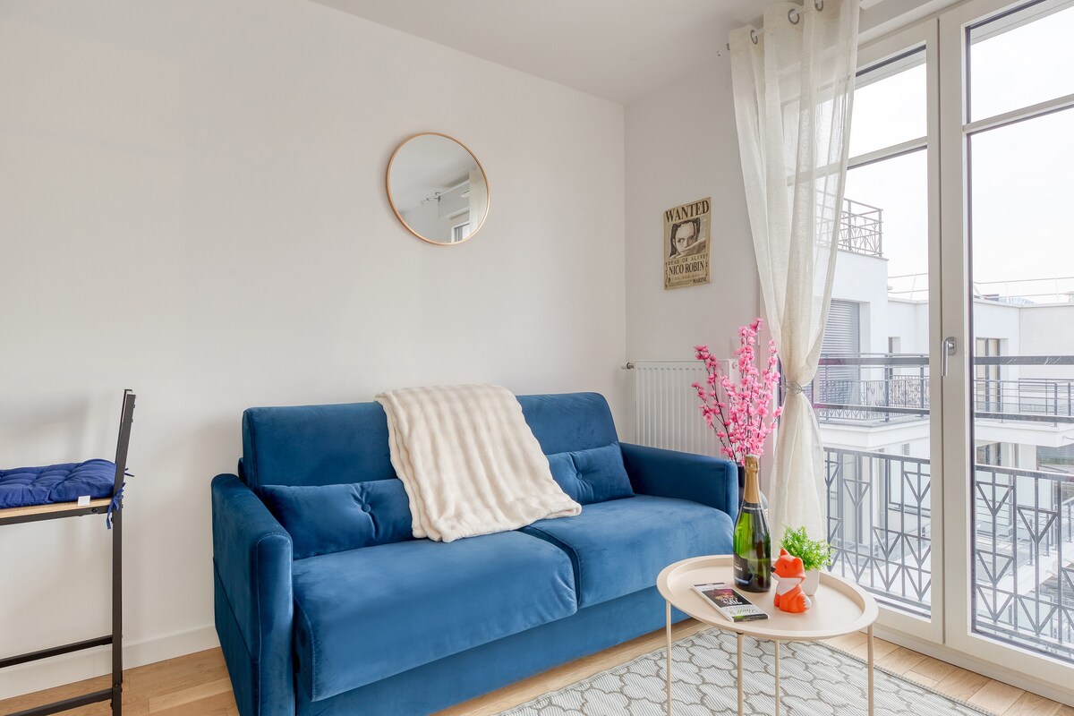 Salon & séjour — Canapé bleu, miroir rond, lumière naturelle abondante