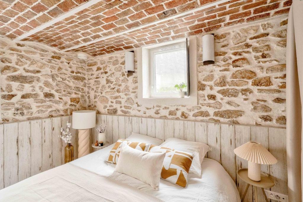 Chambres — Lit blanc, murs pierre, poutres briques, luminaires design