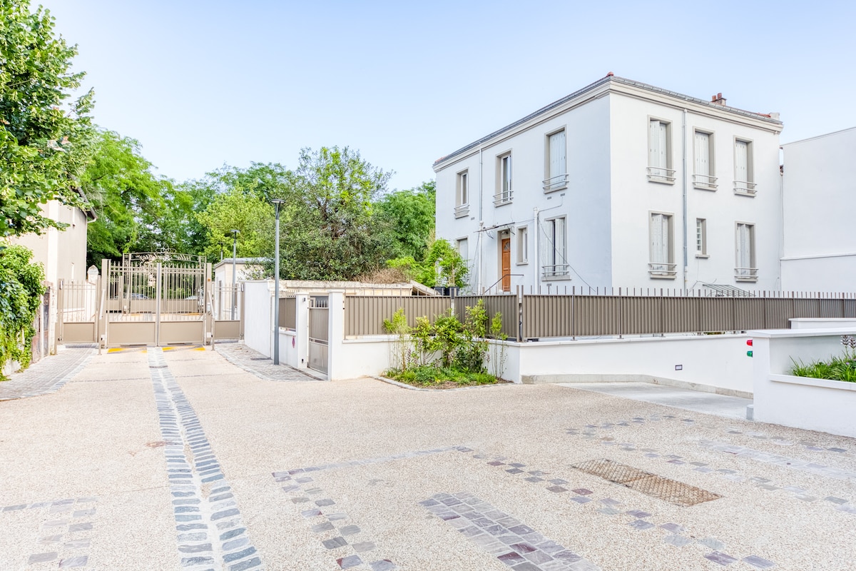 Extérieur — Cour pavée, accès sécurisé, verdure environnante