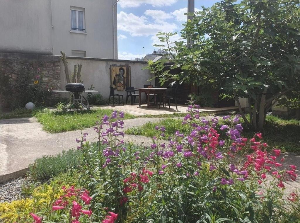 Jardin — Cour fleurie avec phlox colorés, mobilier bois, verdure abondante