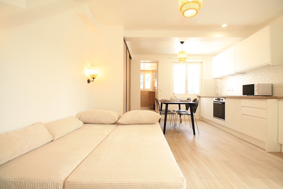Chambres — Lit blanc, cuisine intégrée, ambiance minimaliste et lumineuse