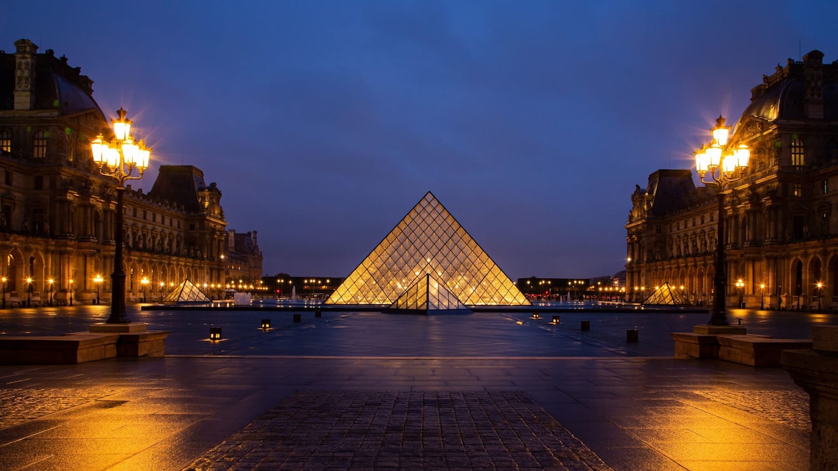 Extérieur — Louvre pyramid illuminated at twilight