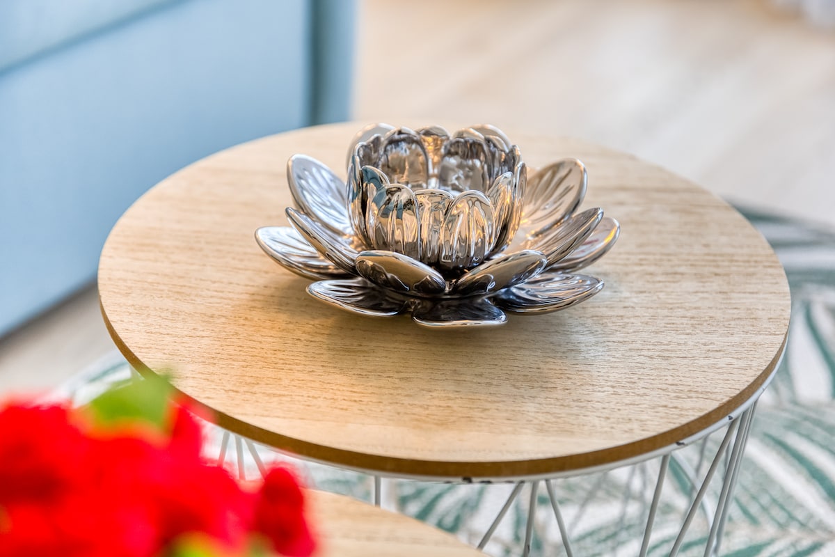 Balcon & terrasse — Table basse ronde bois, décor floral, lumière naturelle douce