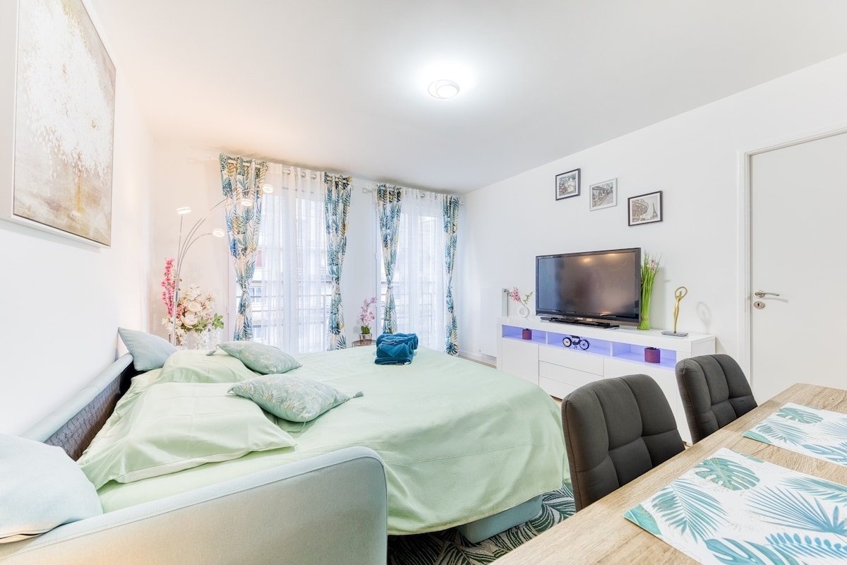 Chambres — Lit lumineux, TV intégrée, ambiance sereine verdâtre