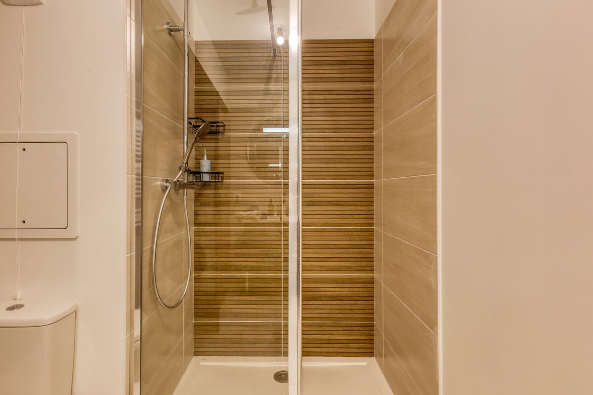 Salle de bain — Douche moderne avec carrelage bois, parois vitrées, éclairage LED