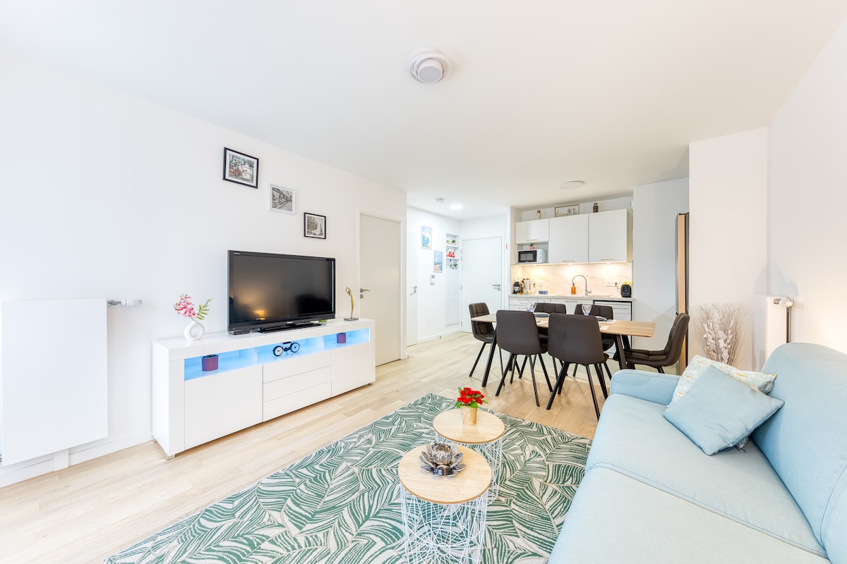 Salon & séjour — Espace lumineux, canapé bleu, téléviseur, meuble blanc