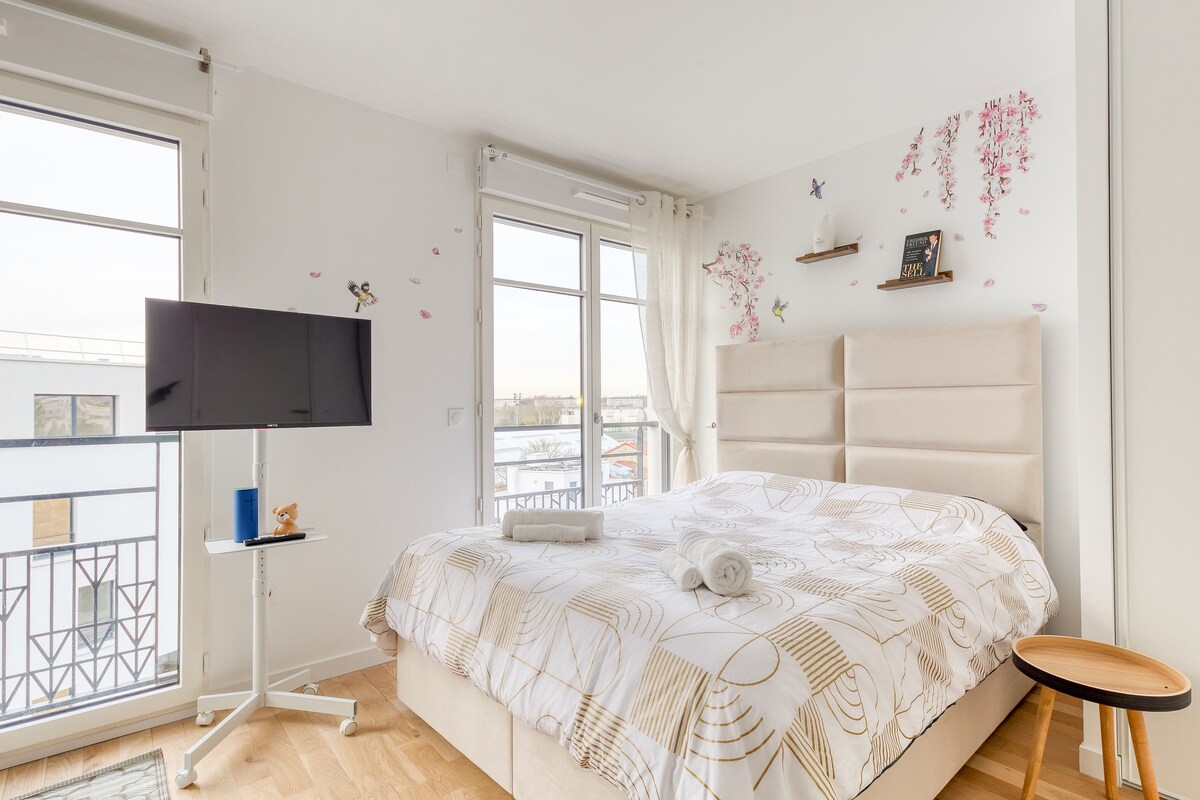 Chambres — Lit spacieux, TV murale, décor floral minimaliste