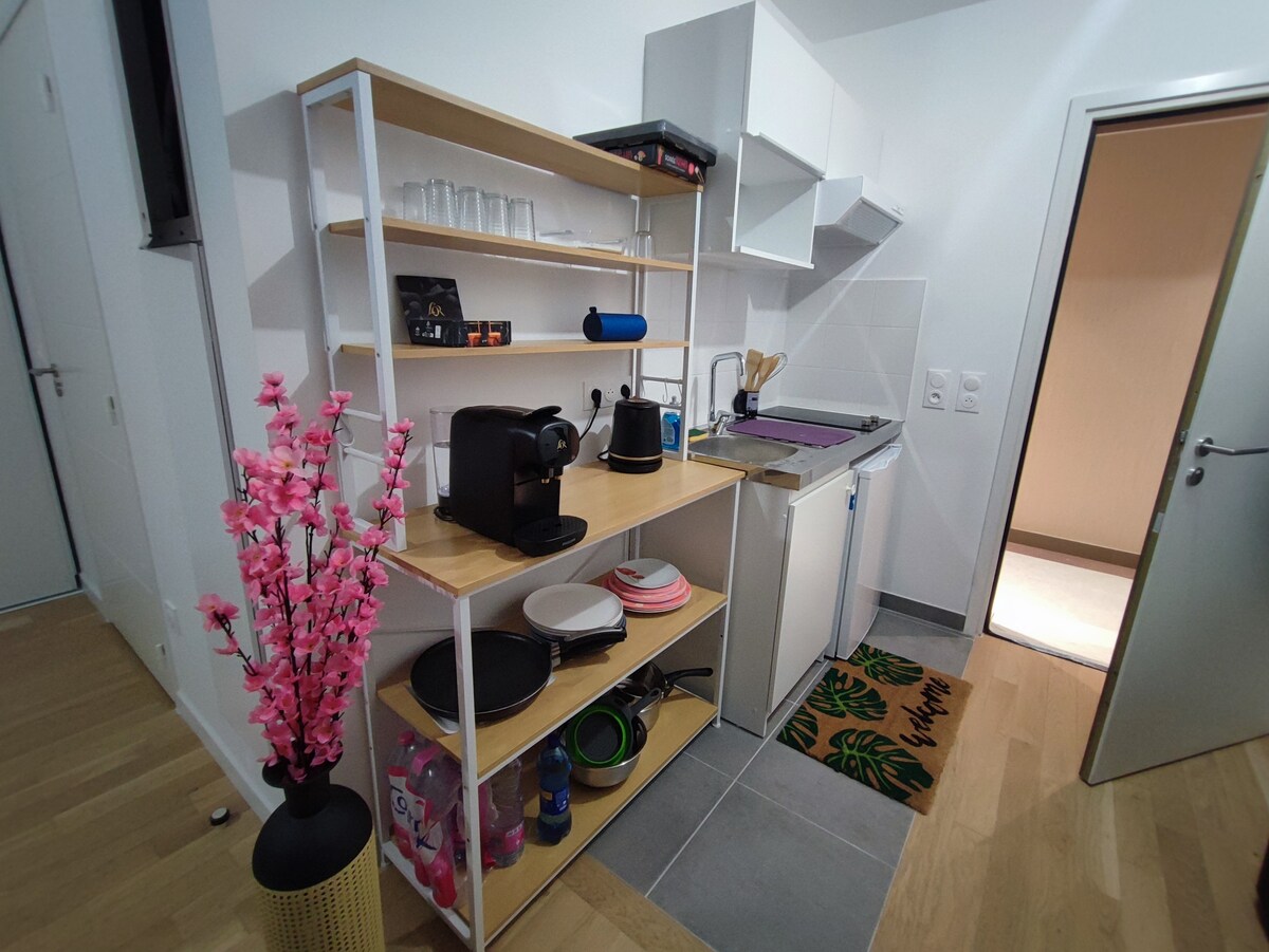 Cuisine — Compact kitchenette with white shelving, appliances and cookware