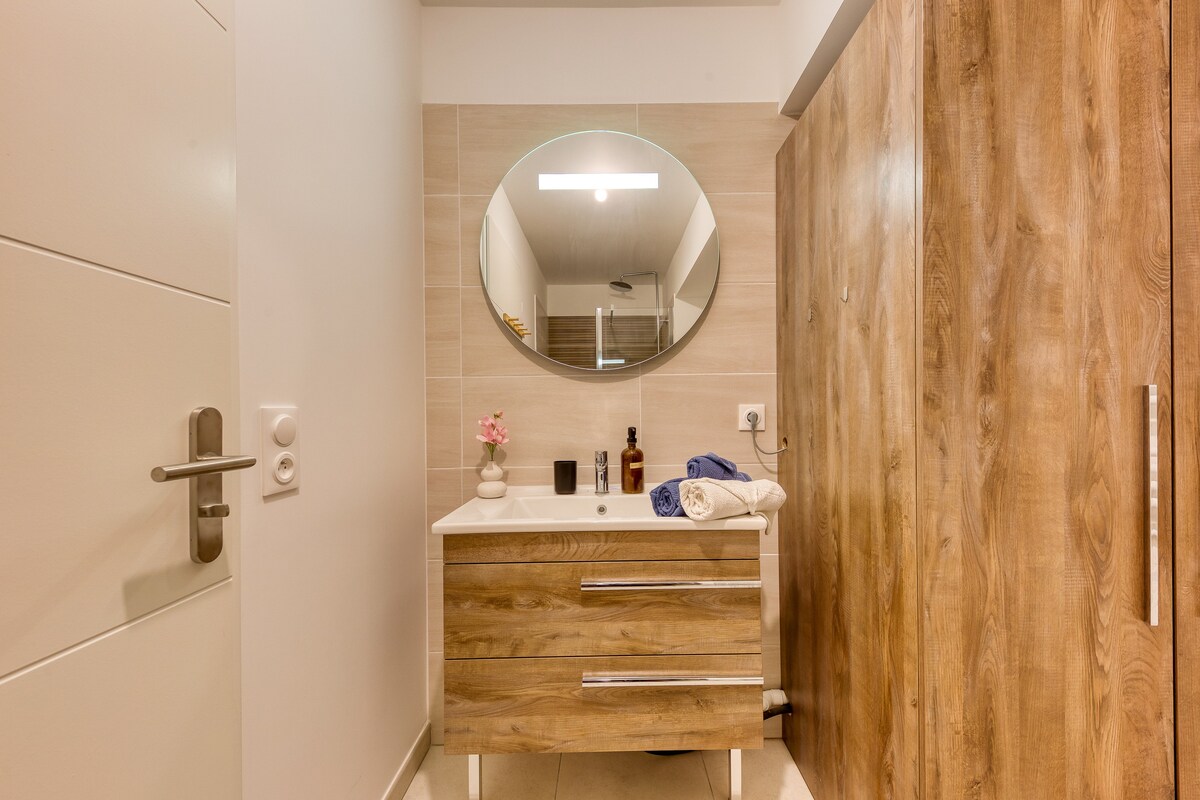 Salle de bain — Vanité bois, miroir rond, éclairage moderne, design épuré