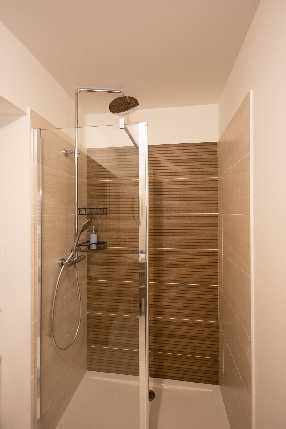Salle de bain — Douche moderne avec carrelage bois, luminosité naturelle douce