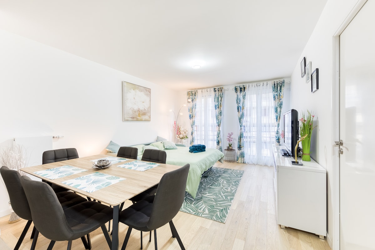 Chambres — Lit vert menthe, table repas noire, luminosité douce