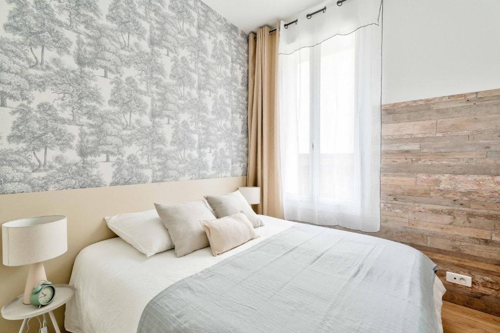 Chambres — Lit blanc, papier peint motifs gris, lumière naturelle douce