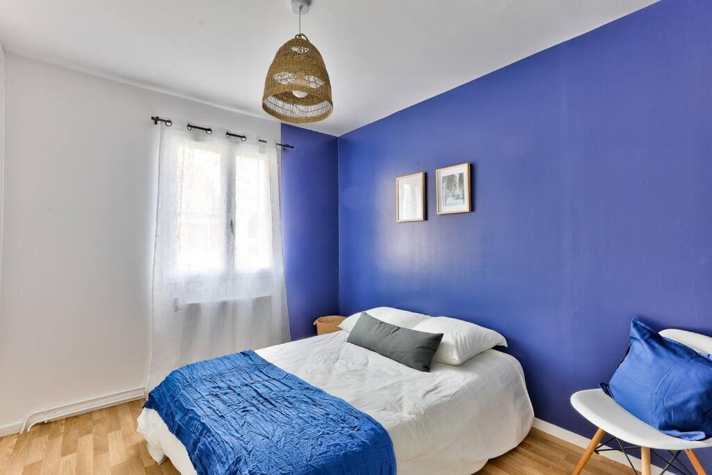 Chambres — Chambre épurée, murs bleus, lit blanc et bleu, lumière naturelle abondante