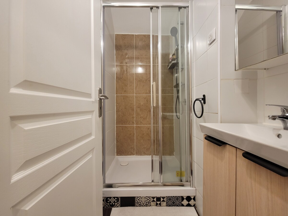 Salle de bain — Douche moderne, carrelage beige, mobilier bois clair