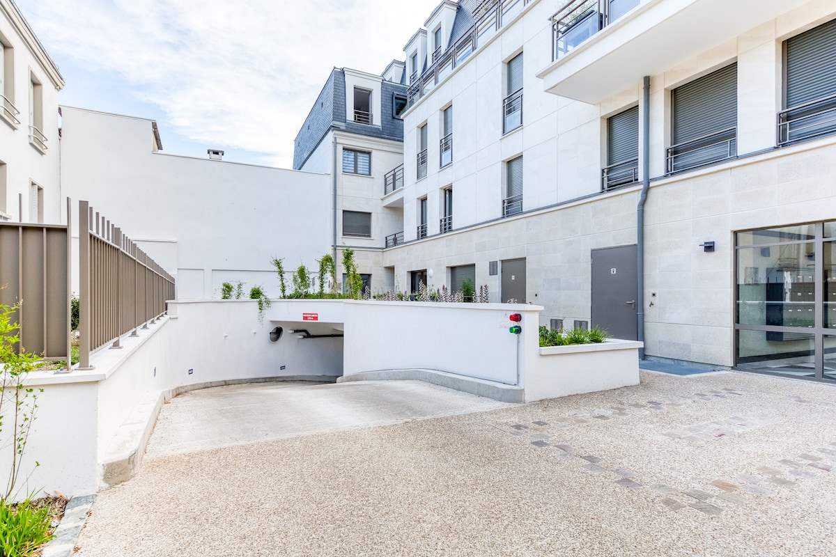 Extérieur — Cour pavée moderne, plantes vertes, architecture épurée
